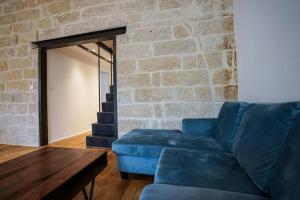 sala de estar con sofá azul y pared de ladrillo en Le petit Corum - HH, en Montpellier