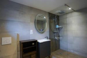 y baño con ducha, lavabo y espejo. en Le petit Corum - HH, en Montpellier