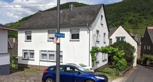 a blue car parked in front of a white house at Ferienwohnung Ewa in Ellenz-Poltersdorf