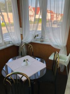 a table with chairs and a bird sitting on top of it at Pension „La Rose“ in Norden
