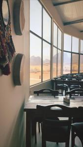 瓦迪拉姆的住宿－Zeina Desert Lodge，窗户房间里一排桌椅