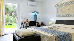 a bedroom with a bed and a table and a window at Sole Matto Rooms in Olbia