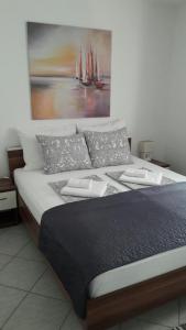 1 cama grande con almohadas y una pintura en la pared en Apartments Edo, en Vis