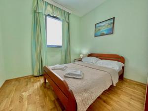 a bedroom with a bed and a window at Plava Vila Beach Apartments Sveti Stefan in Sveti Stefan