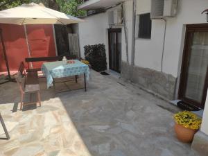 a patio with an umbrella and a table and a chair at Poseidon Rooms in Kala Nera