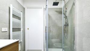 a shower with a glass door in a bathroom at Sole Matto Rooms in Olbia