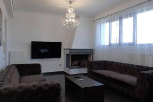 a living room with two couches and a fireplace at Filippos Acharnes Elegance in Akharnaí