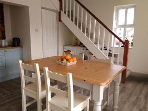 een keuken met een tafel met een kom sinaasappels bij 43 Reidhlean Clifden Glen in Galway
