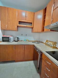 a kitchen with wooden cabinets and a microwave at Plava Vila Beach Apartments Sveti Stefan in Sveti Stefan