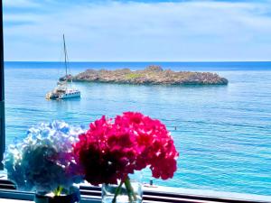 a view of a boat in the water with flowers at Plava Vila Beach Apartments Sveti Stefan in Sveti Stefan