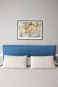 a bed with two pillows and a painting on the wall at Casa Thalassa in Cefalù