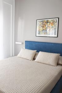 a bed with a blue headboard and two pillows at Casa Thalassa in Cefalù
