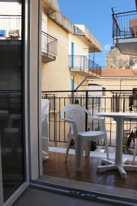 a balcony with a table and a table and a chair at Casa Thalassa in Cefalù