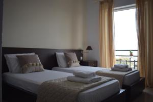 a bedroom with two beds with towels on them at Tokalis Boutique Hotel & Spa in Nea Anchialos