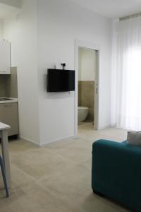 a living room with a couch and a tv on a wall at Casa Thalassa in Cefalù +21 photos
