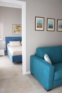 a living room with a blue couch and a bed at Casa Thalassa in Cefalù