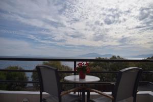 a table and chairs on a balcony with a view of the water at Tokalis Boutique Hotel & Spa in Nea Anchialos
