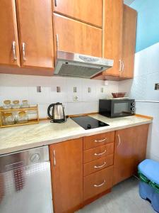 a kitchen with wooden cabinets and a stove top oven at Plava Vila Beach Apartments Sveti Stefan in Sveti Stefan