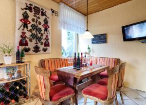 a dining room with a wooden table and chairs at Weingut Christoffel in Kövenig