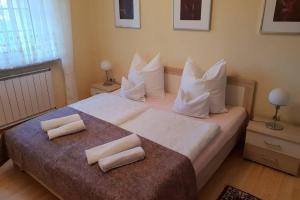 1 dormitorio con 1 cama grande con almohadas blancas en The Pearl of the Danube Bend - Regina Apartman, en Dunabogdány