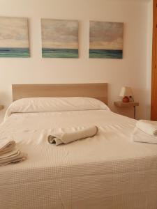 a white bed with a white towel on it at 2ºA Escobar in Nerja