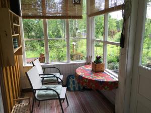 MaxmoにあるGula Villanのテーブルと椅子、窓が備わる客室です。