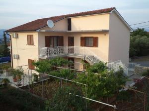 a house with a balcony on a hill at Apartman Neda in Sveti Ivan Dobrinjski