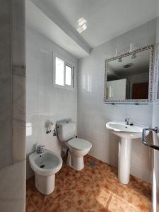 a white bathroom with a toilet and a sink at 3ºB Escobar in Nerja +28 photos