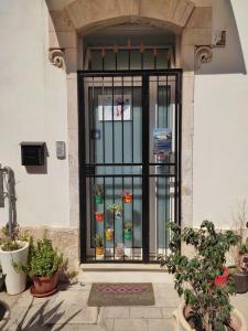 einen Eingang zu einem Gebäude mit einem Tor mit Topfpflanzen in der Unterkunft Regina Lucia casa vacanze in Syrakus