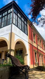 un banco sentado frente a un edificio en La Venta de Miyares - Casa de Indianos, en Piloña