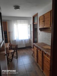 a kitchen with wooden cabinets and a window at Iris&carina in Eforie Sud