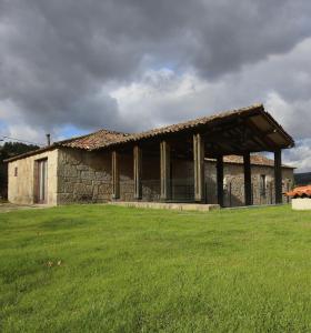 ein großes Steingebäude mit einem Grasfeld davor in der Unterkunft Quinta de Fermil - Casas in Vouzela