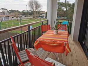 - une terrasse couverte avec une table et des chaises sur un balcon dans l'établissement IMARENA, à Capbreton