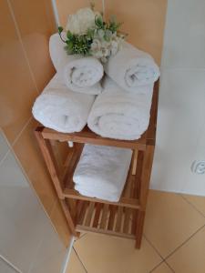 a stack of towels on a shelf in a bathroom at Gray House Apartmán in Zlaté Hory