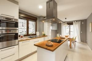 a kitchen with white cabinets and a wooden counter top at Casa Clara in Isla de Arosa