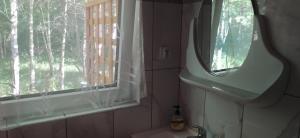 a bathroom with a mirror and a sink and a window at Domek letniskowy Szramowo (bliźniak) in Szramowo