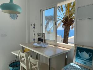 a room with a table and a window with a palm tree at San Agustín Seaviews and flowers in San Agustin