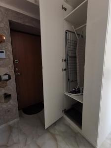 Zimmer mit einem Schrank mit einer Tür und Fliesenboden in der Unterkunft Rotušės apartamentai Kretingoje in Kretinga