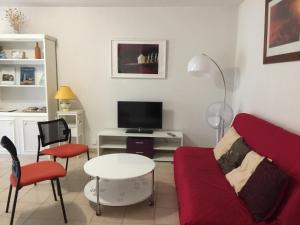 a living room with a red couch and a tv at Les Capucins in Carcassonne