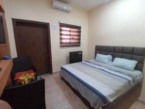 Un dormitorio con una cama con almohadas azules y una ventana en Relax House For Studio Rooms Apartment, en Áqaba