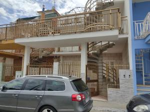 a minivan parked in front of a building with a balcony at Casa Solemare in Torre Lapillo