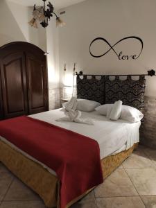 a bedroom with a large bed with a love sign on the wall at Casa Solemare in Torre Lapillo