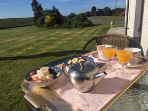 a table with a tea pot and a plate of food at Rural Farmhouse in Poughill