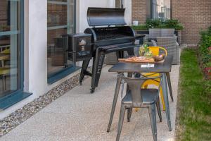 a grill and a piano outside of a house at Campanile Fontainebleau in Fontainebleau