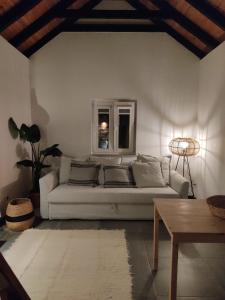 a living room with a white couch and a window at Villa Vista in Sesimbra