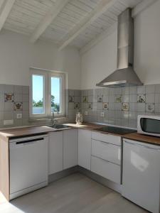 a kitchen with white cabinets and a stove top oven at Villa Vista in Sesimbra