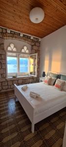 a bedroom with a large white bed with a stone wall at Beach front AmF Holiday Home in Lopud