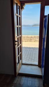 una puerta abierta con vistas a la playa en Beach front AmF Holiday Home, en Lopud Island