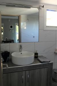 a bathroom with a sink and a mirror at Chalkidiki Beach House in Nea Potidaea