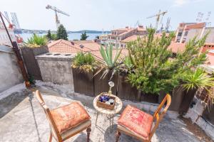a patio with two chairs and a table on a balcony at Diana's Chamber in Pula